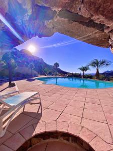 vistas a una piscina con mesa y banco en Hôtel Domaine A Flatta, en Calenzana