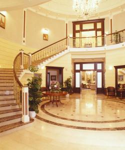 a large lobby with a staircase and a table at Baltic Star Villas in Petergof