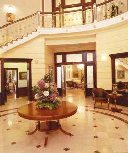 a lobby with a table with a vase of flowers on it at Baltic Star Villas in Petergof