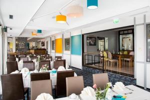 uma sala de jantar com mesas e cadeiras e um restaurante em Hotel Deynique em Westerburg