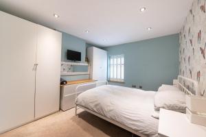 - une chambre avec un lit et une télévision murale dans l'établissement Besford Square, Shrewsbury Town, à Shrewsbury