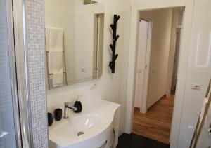 a white bathroom with a sink and a mirror at Il Casale del Borgo in Cancellara +42 photos