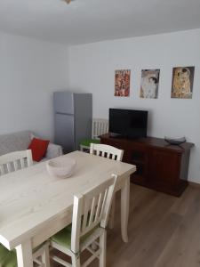 a dining room with a table and chairs and a television at Casa Caliman in Santa Caterina