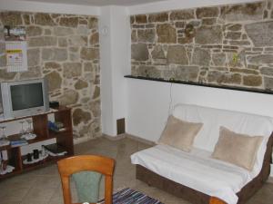 a room with a couch and a tv and a chair at Apartment Roby in Vrsar