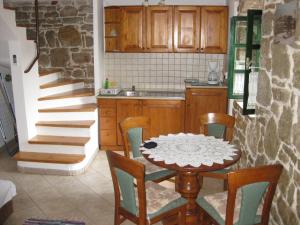 a kitchen with a table and chairs and a staircase at Apartment Roby in Vrsar