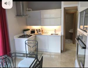 a kitchen with white cabinets and a glass table at Luxurious Studio Apartment in Fahan Co Donegal in Fahan