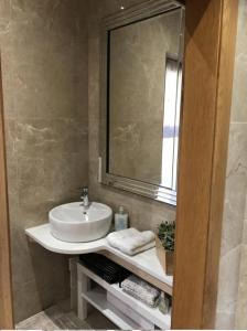 W łazience znajduje się umywalka i lustro. w obiekcie Luxurious Studio Apartment in Fahan Co Donegal w mieście Fahan