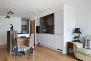 een keuken en een woonkamer met een tafel en een bank bij No. 5 Warriston, Canonmills Luxury Apartment in Edinburgh