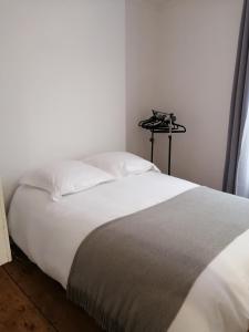 - une chambre avec un lit blanc et un appareil photo sur un tripode dans l'établissement MAGNIFIQUE ESCALE POITEVINE. THE PLACE TO BE, à Poitiers
