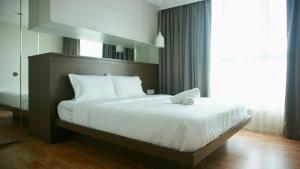 a bedroom with a large bed with white sheets at Verve Suites KL South in Kuala Lumpur