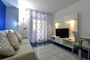 a living room with a couch and a television at Sunshine House in Sorrento