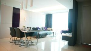 a living room with a bed and a table and chairs at Verve Suites KL South in Kuala Lumpur