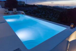 a large blue swimming pool on top of a house at White Orchid Villa in Pyrgos