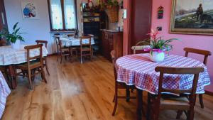 een eetkamer met 2 tafels en stoelen en roze muren bij Bed & Breakfast Barba Bertu in Frassino