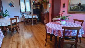comedor con 2 mesas y sillas y paredes rosas en Bed & Breakfast Barba Bertu, en Frassino