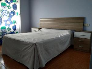 a bedroom with a bed and a wooden headboard at Casa Xancin in Ribadeo