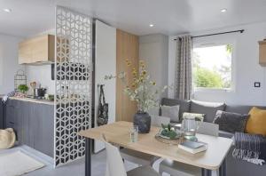 eine Küche und ein Wohnzimmer mit einem Tisch im Zimmer in der Unterkunft Prachtig nieuw chalet met tuin op De Friese Wadden in Tzummarum