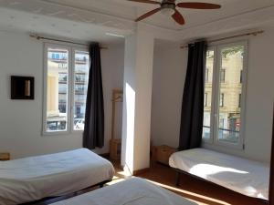 a bedroom with two beds and two windows at Russafa Youth Hostel in Valencia