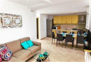 a living room and kitchen with a couch and a table at Villa Oniro- Less than 5-Min Walk to Kalivaki Beach in Georgioupolis