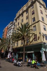 a tall building with palm trees in front of it at Russafa Youth Hostel in Valencia