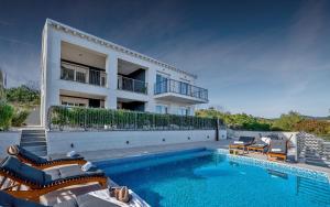 uma casa com piscina ao lado de um edifício em Luxury Authentic Experience at Villa Marta em Lumbarda