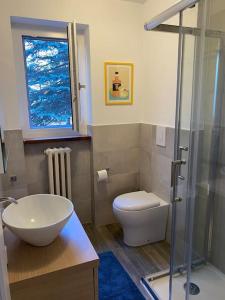 une salle de bain avec un lavabo et des toilettes et une fenêtre dans l'établissement TRILOCALE SULLE PISTE Appena RISTRUTTURATO, à Sauze dʼOulx