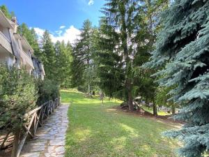 un jardin avec des arbres et un chemin à côté d'une maison dans l'établissement TRILOCALE SULLE PISTE Appena RISTRUTTURATO, à Sauze dʼOulx