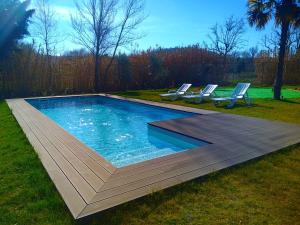 a swimming pool with two lounge chairs in the grass at Carregã Water mill in Penela