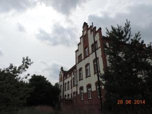 un grande edificio in mattoni con alberi di fronte di Hotel Carl von Clausewitz a Burg bei Magdeburg