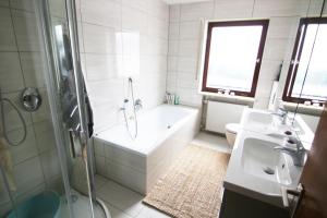 een badkamer met een douche, een bad en een wastafel bij Familienzimmer in Neumarkt in der Oberpfalz