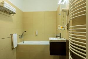 a bathroom with a tub and a sink at Hotel Lužnice in Planá nad Lužnicí
