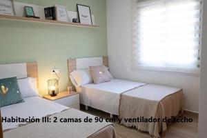 1 dormitorio con 2 camas y ventana en Arrecife 3 dormitorios, en Peñíscola