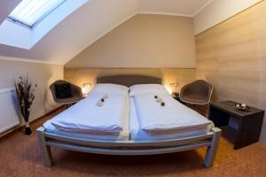 a bedroom with a bed and two chairs at Hotel Lužnice in Planá nad Lužnicí