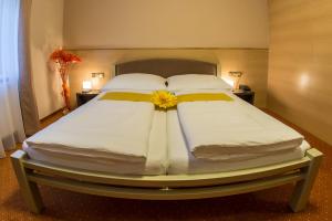 a large bed with a yellow flower on top of it at Hotel Lužnice in Planá nad Lužnicí