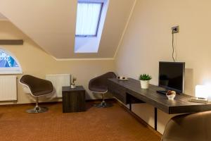 a room with a desk with chairs and a tv at Hotel Lužnice in Planá nad Lužnicí