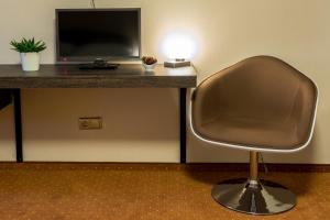 a chair in front of a desk with a computer monitor at Hotel Lužnice in Planá nad Lužnicí