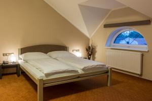 a bedroom with a bed with a large window at Hotel Lužnice in Planá nad Lužnicí