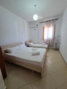 a bedroom with two beds and a window at Guesthouse Emanuel in Ksamil
