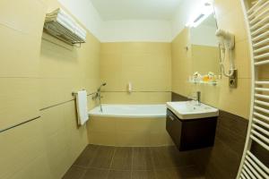 a bathroom with a bath tub and a sink at Hotel Lužnice in Planá nad Lužnicí