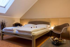 a bedroom with a large bed with white sheets and pillows at Hotel Lužnice in Planá nad Lužnicí