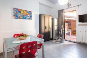 a dining room with a glass table and red chairs at Casa dell'Ulivo in Aci Bonaccorsi