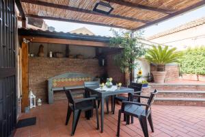 un patio con mesa, sillas y banco en Casa dell'Ulivo en Aci Bonaccorsi