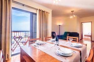 une salle à manger avec une table et une grande fenêtre dans l'établissement LULINA Two Bedroom by ALMA Holiday Rentals, à Funchal