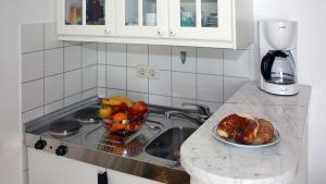 un bancone della cucina con lavandino e cesto di frutta di Strandhaus Ott a Hagnau