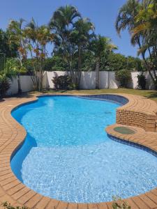 a swimming pool with blue water in a yard at Hacienda Palms in Richards Bay