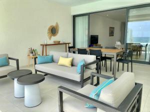 a living room with a couch and chairs and a table at East Coast Beachfront Luxury - Eastern Blue Apartments in Poste Lafayette