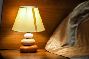 a wooden lamp sitting on a table next to a bed at Armada Comfort Hotel in Orenburg