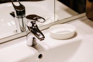 a bathroom sink with a faucet and a soap dish at Armada Comfort Hotel in Orenburg