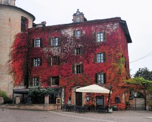 Um edifício antigo com hera vermelha. em L'Aromatario em Neive