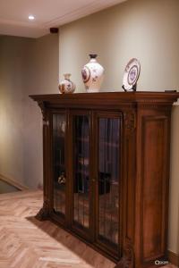 a wooden cabinet with three vases on top of it at Vila Sonnet in Korçë